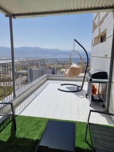a balcony with a chair and a swing at דירת גג נוף המפרץ 1105-6 in Eilat