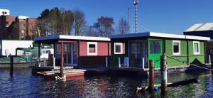 zwei Häuser auf einer Anlegestelle im Wasser in der Unterkunft Hausboot Wilhelmshaven - Traum Unterkunft an der Jade in Wilhelmshaven