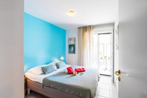 une chambre avec des murs bleus et un lit avec des oreillers rouges dans l'établissement PALAIS LIBERTE V AP4267 By Riviera Holiday Homes, à Nice