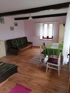 sala de estar con mesa verde y sofá en Domek blisko Biebrzy en Radziłów