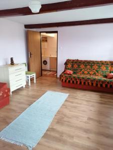 sala de estar con sofá y alfombra en Domek blisko Biebrzy, en Radziłów