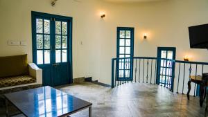 a living room with a black door and a table at Hydrangea Villa in Kodaikānāl