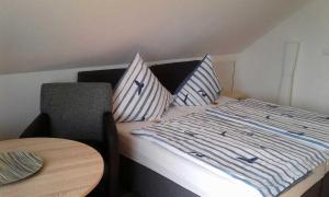 a bed with blue and white striped sheets and pillows at Rügen Fewo 284 in Neu Mukran