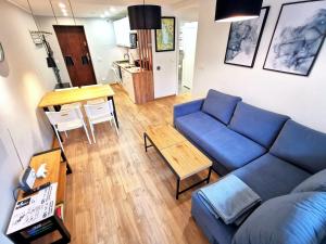 sala de estar con sofá azul y mesa en Apartament z Widokiem na Park en Polanica-Zdrój