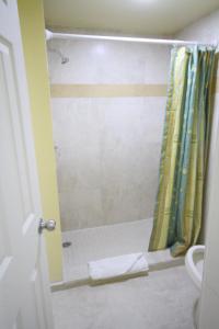 a bathroom with a shower with a yellow shower curtain at Sinbad Motel in Miami