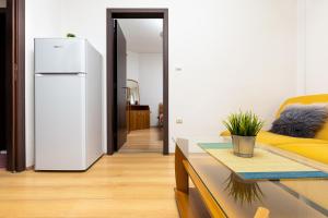 a living room with a white refrigerator and a couch at Lovely 1BD Apartment close to the Summer Theatre by Flat Mаnager in Plovdiv