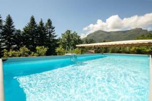 a swimming pool with blue water and mountains in the background at Modern apartment with 2 bedrooms Casa Perla by VacaVilla in Camaiore
