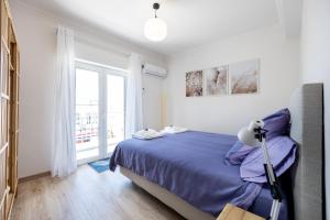 a bedroom with a bed and a large window at Casa do Mercado in Olhão