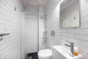 a white bathroom with a toilet and a sink at Casa do Mercado in Olhão +17 photos