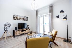 a living room with a tv and a table and chairs at Casa do Mercado in Olhão