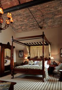 a bedroom with a canopy bed with a brick ceiling at Peckforton Castle in Tarporley