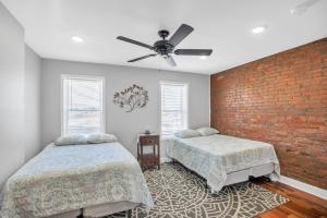 a bedroom with two beds and a brick wall at Enjoy Your Stay in this Amazing Location in Philadelphia! home in Philadelphia