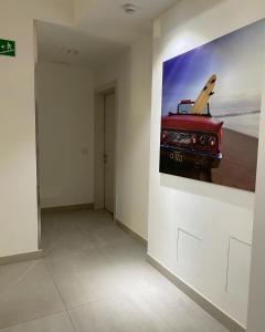 ein Zimmer mit einem Gemälde eines roten Wagens an der Wand in der Unterkunft Hotel Aurora & Appartamenti in Nago-Torbole