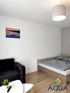 - une petite chambre avec un lit et une chaise dans l'établissement Willa Aqua, à Jastrzębia Góra