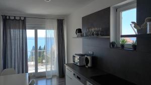 a kitchen with a microwave on a counter with a window at Villa Helena in Dramalj