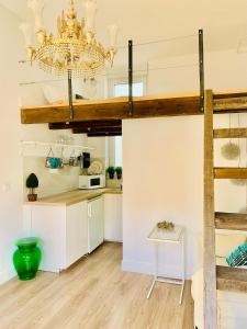 a kitchen with a loft bed and a chandelier at Mini Loft Plaza España in Jerez de la Frontera