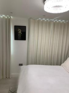 Horndon on the Hill的住宿－A BYK luxury modern home that sleeps 2 - 8 people，卧室配有白色的床和吊灯。