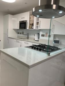 a kitchen with a white counter top and a stove at A BYK luxury modern home that sleeps 2 - 8 people in Horndon on the Hill