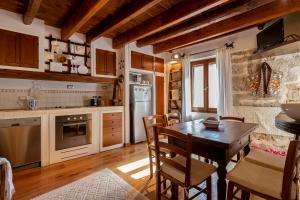 Una cocina con una mesa y sillas en una habitación. en Chalet vista mare Free wi-fi e Aria condizionata, en Alghero