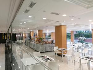 a dining room with white tables and white chairs at Hotel Marítimo Ris con garaje in Noja
