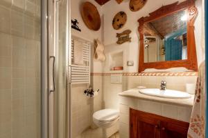 Un baño con inodoro, lavabo y espejo. en Chalet vista mare Free wi-fi e Aria condizionata, en Alghero