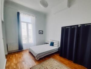 - une chambre avec un lit et une grande fenêtre dans l'établissement Spacieux et lumineux appartement vue mer Joliette, à Marseille