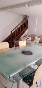 a glass table in a living room with a couch at Maison au coeur d'un village près d'Angoulême in Champniers