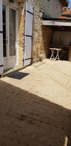 um pátio com uma mesa em frente a um edifício em Maison au coeur d'un village près d'Angoulême em Champniers