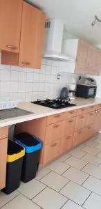 a kitchen with wooden cabinets and a stove top oven at Maison au coeur d'un village près d'Angoulême in Champniers