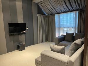 a living room with a couch and a tv at Ohana Suites Yogyakarta in Ngabean