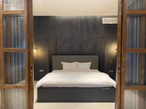 a bedroom with a bed with a black wall at Ohana Suites Yogyakarta in Ngabean