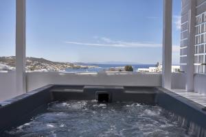 bañera de hidromasaje en el balcón de un edificio en Periscope Suite Private Jacuzzi en Drafaki