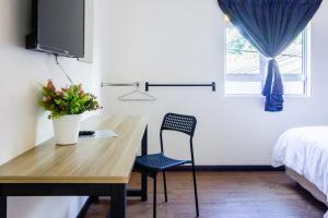 een kamer met een bureau, een stoel en een bed bij Explore 5BR Gardenhouse Retreats (Free Parking) in Butterworth