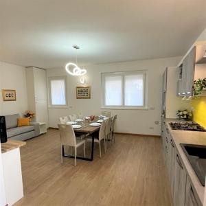 cocina y comedor con mesa y sillas en GIORNI FELICI: appartamento tutto nuovo, giardino, parcheggio, en Verbania