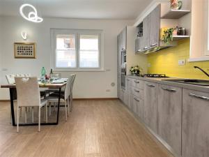 a kitchen with a table and a dining room at GIORNI FELICI: appartamento tutto nuovo, giardino, parcheggio in Verbania