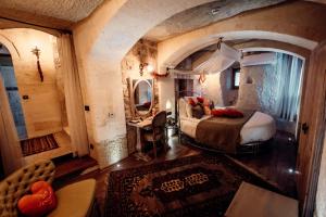 a bedroom with a large bed in a room with an arch at Tafoni Houses Cave Hotel in Ortahisar