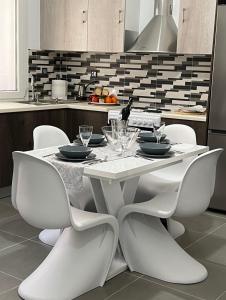 a white dining table and chairs in a kitchen at Thania's House ,4 minutes from the center of Hermoulis in Ermoupoli