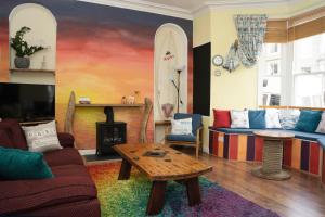 a living room with a couch and a table and surfboards at EasyPZ Stay in Penzance