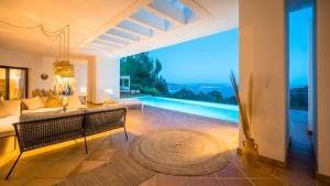 a living room with a view of a swimming pool at Villa El Mirador Uno in Es Cubells