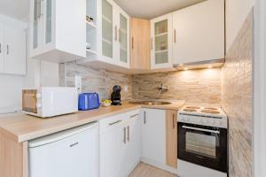 eine weiße Küche mit weißen Schränken und einem Waschbecken in der Unterkunft Apartment Eli in Split
