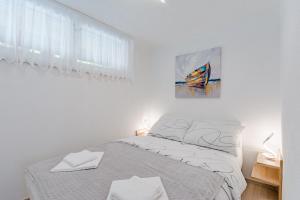 um quarto branco com uma cama e um quadro na parede em Apartment Eli em Split