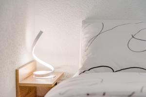 łóżko z białą poduszką i lampką na nocnym stoliku w obiekcie Apartment Eli w Splicie