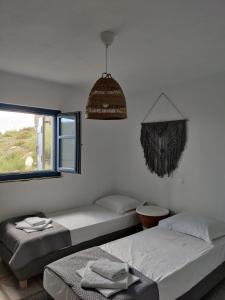 a bedroom with two beds and a window at Aeraki in Kithnos