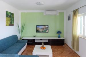 ein Wohnzimmer mit einem blauen Sofa und einem Tisch in der Unterkunft Apartment Tanja in Kaštela