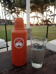 een fles ketchup en een glas water op een tafel bij CocoVilla Boutique Resort in Beruwala