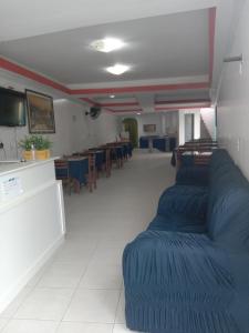 salon z niebieskimi kanapami i jadalnią w obiekcie Pousada Residencial Benfica w mieście Porto Seguro