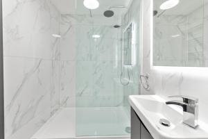 a white bathroom with a shower and a sink at Town House Rooms in Boston