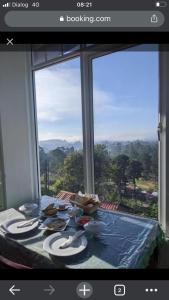 uma mesa com comida e vista para uma janela em King's Lodge em Nuwara Eliya