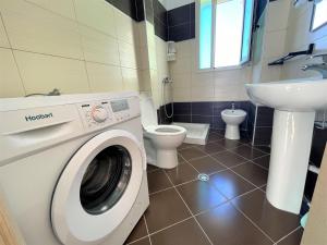 une salle de bains avec lave-linge et lavabo dans l'établissement Brand24 Apartment, à Vlorë