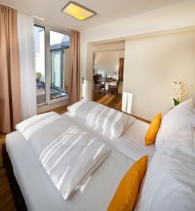 ein Schlafzimmer mit einem großen weißen Bett mit gelben Kissen in der Unterkunft GuestHouse Mannheim in Mannheim